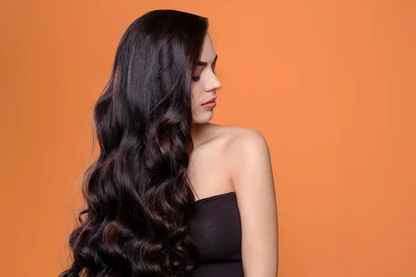 Retrato de modelo bonito com cabelo encaracolado lindo no fundo de cor — Fotografia de Stock
