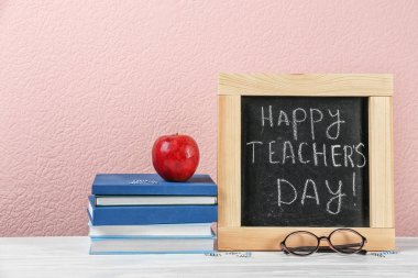 Öğretmenin gün masada için küçük kara tahta ile kompozisyon