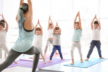 Küçük çocuklar ve pratik spor salonunda yoga öğretmeni