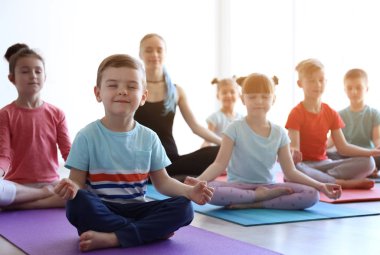 Küçük çocuklar ve pratik spor salonunda yoga öğretmeni
