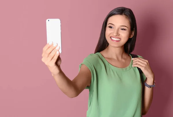 Jovem bela mulher tomando selfie contra fundo de cor — Fotografia de Stock