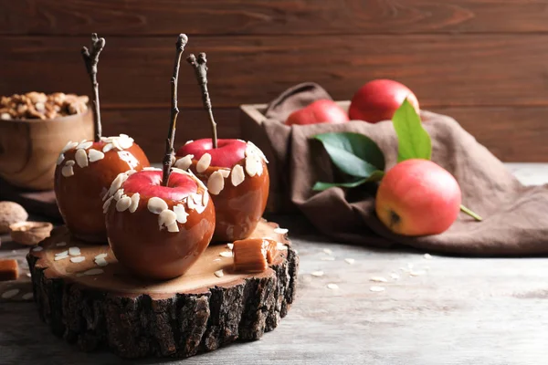 Köstliche Karamelläpfel auf hölzernem Servierbrett — Stockfoto