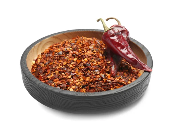 Tallrik med krossad chili peppar och skida på vit bakgrund — Stockfoto