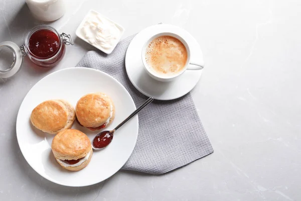 Scones saborosos com creme coagulado e geléia no fundo cinza, vista superior — Fotografia de Stock