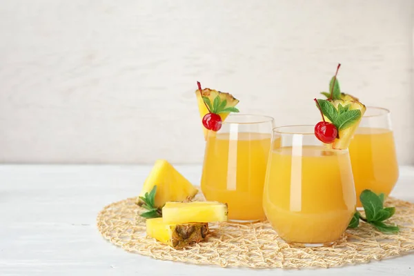 Vasos con delicioso jugo de piña en la mesa — Foto de Stock