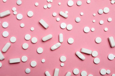 Farklı hap ve kapsül düz renkli arka plan üzerinde yatıyordu