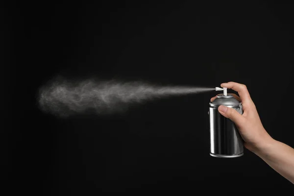 Mulher pulverizando purificador de ar no fundo preto, close-up — Fotografia de Stock
