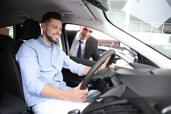 Πωλητής διαβούλευση με νεαρός άνδρας στο auto σε αντιπροσωπεία. Αγορά νέου αυτοκινήτου — Φωτογραφία Αρχείου