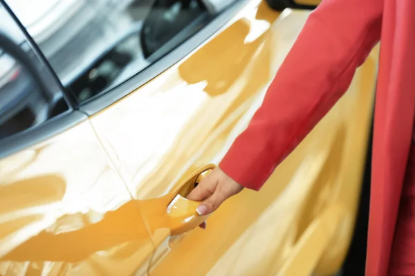 Mujer joven abriendo la puerta de coche nuevo, primer plano — Foto de Stock