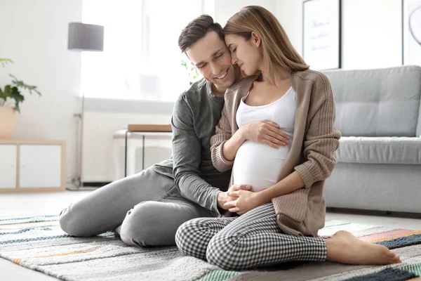 Jeune femme enceinte avec son mari à la maison — Photo