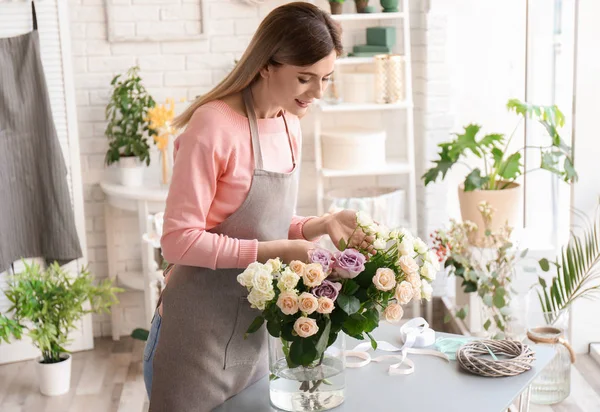 Florista femenina con rosas en el lugar de trabajo — Foto de Stock