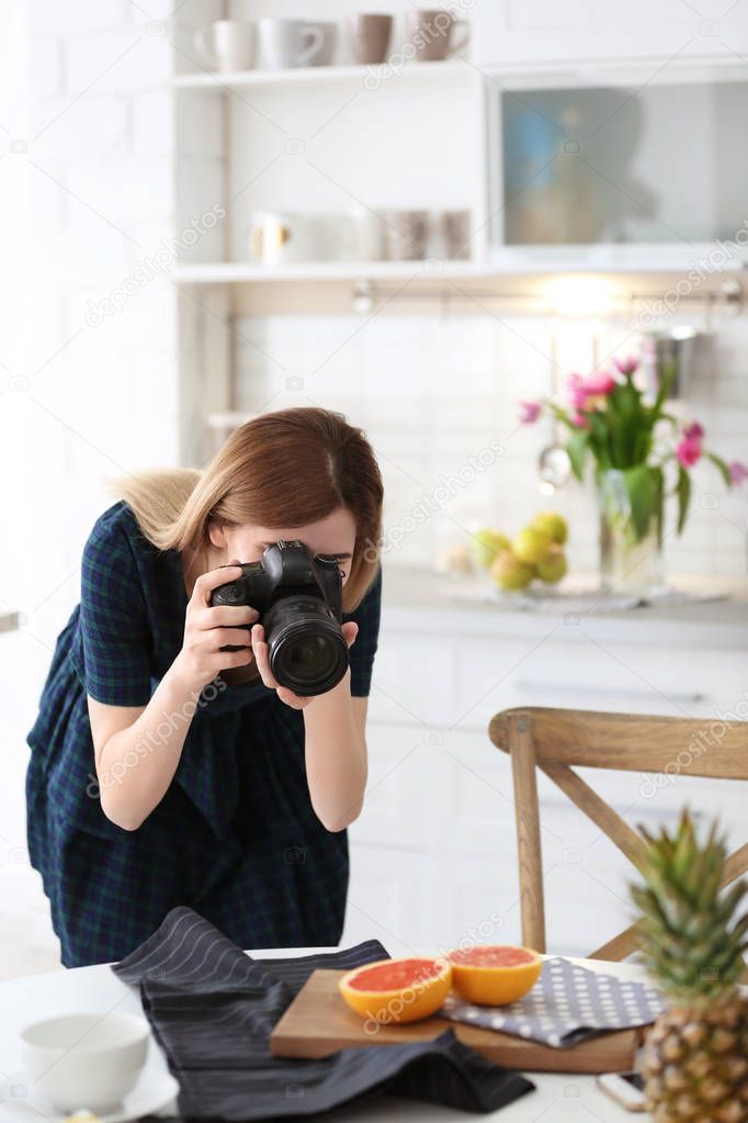 Young blogger taking photo of food in kitchen