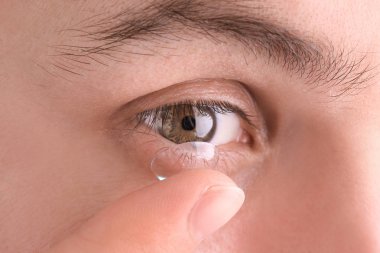 Onun gözünde, closeup koyarak Kontakt lens genç adam