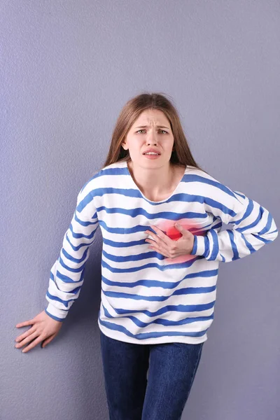 Junge Frau mit Herzinfarkt vor farbigem Hintergrund — Stockfoto