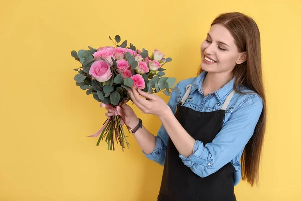 Floristería femenina con ramo de hermosas flores sobre fondo de color — Foto de Stock