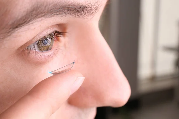 Jovem colocando lente de contato em seu olho, close-up — Fotografia de Stock