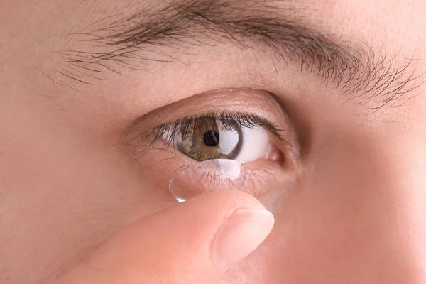 Jovem colocando lente de contato em seu olho, close-up — Fotografia de Stock