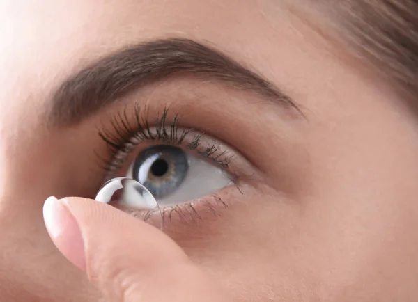 Mulher jovem colocando lente de contato em seu olho, close-up — Fotografia de Stock