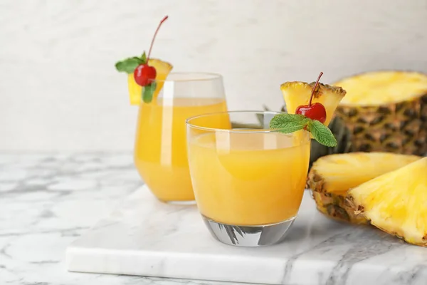 Bril met heerlijke ananassap op tafel — Stockfoto