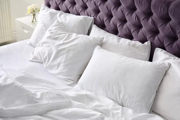 Удобная кровать с белым бельем дома — стоковое фото