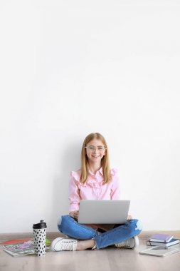 Sevimli genç blogger ile kat hafif duvarın üstünde laptop