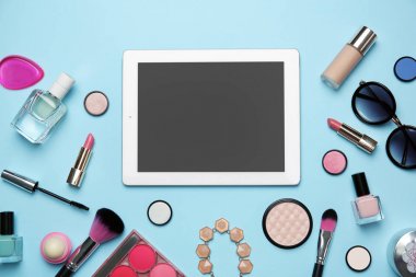 Kadın renk arka plan üzerinde için tablet ve makyaj ürünleri ile düz yatıyordu kompozisyon