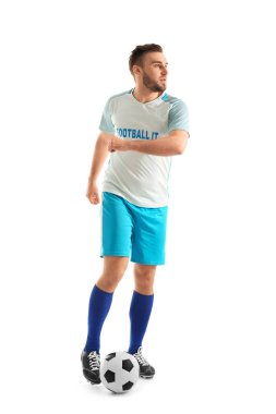 Genç adam beyaz arka planda futbol oynuyor.