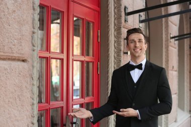 Şık takım elbise ayakta Restoran girişine yakın genç kapıcı