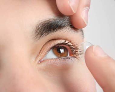 Genç koyarak Kontakt lens gözüne, tatlı adam.