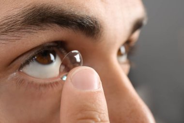 Genç koyarak Kontakt lens gözüne, tatlı adam.
