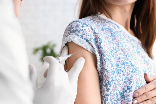 Läkare vaccinerande kvinnlig patient på klinik — Stockfoto