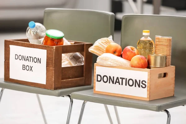 Cajas de donaciones con productos alimenticios en sillas interiores — Foto de Stock