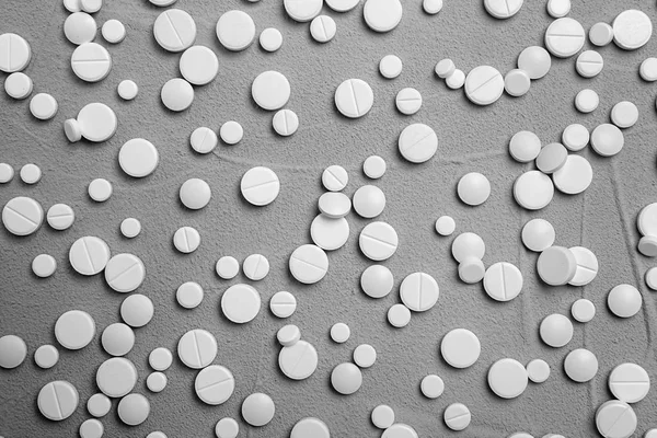 Pillole bianche su sfondo grigio, posa piatta — Foto Stock