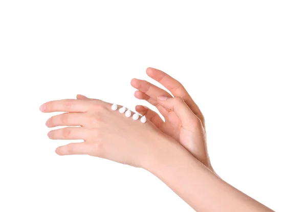 Молодая женщина наносит крем на руки на белом фоне, крупным планом — стоковое фото