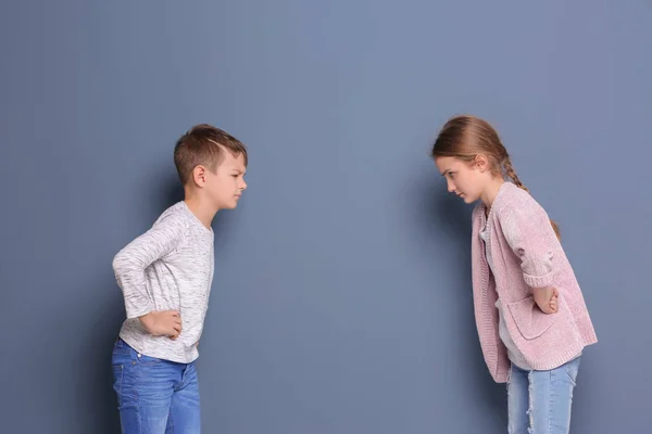 Brother arguing with sister on color background — Stock Photo, Image