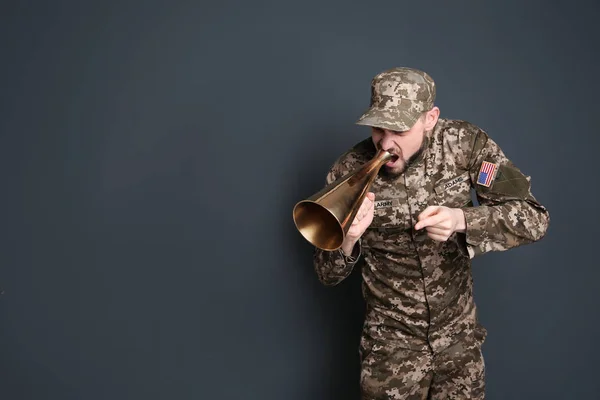 Military man shouting into megaphone on gray background — Stock Photo, Image