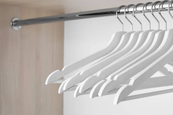 Perchas de ropa sobre riel metálico en armario — Foto de Stock