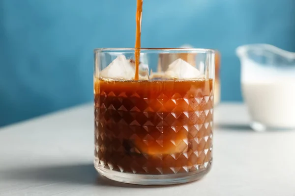 Verser du café froid dans du verre sur la table — Photo