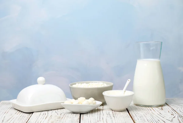 Produtos lácteos diferentes na mesa de madeira — Fotografia de Stock