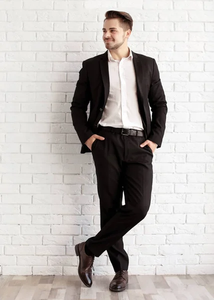 Stilig ung man i elegant kostym och läderskor nära tegelvägg — Stockfoto