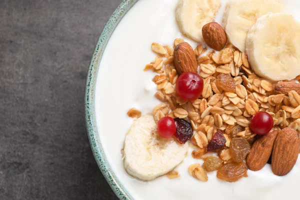 Bowl with yogurt, banana and granola on table, top view — Stock Photo, Image