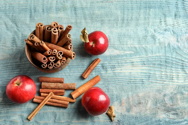 Verse appels en kaneelstokjes op houten tafel, bovenaanzicht — Stockfoto