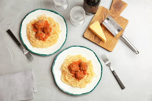 Delicious pasta with meatballs and tomato sauce on grey background, flat lay — Stock Photo, Image