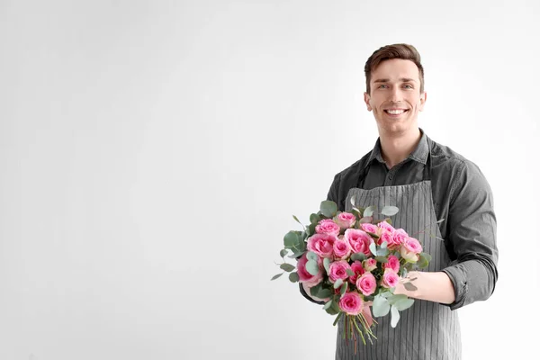 Floristería masculina con ramo de hermosas flores sobre fondo claro — Foto de Stock