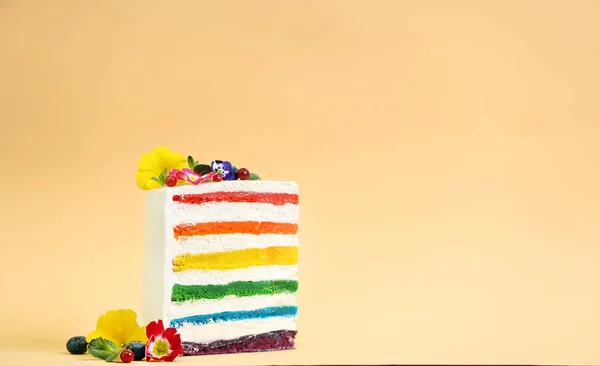 Rebanada de delicioso pastel de arco iris con flores en el fondo de color —  Fotos de Stock