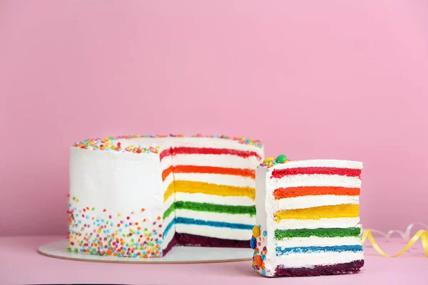 Вкусный радужный торт на цветном фоне — стоковое фото