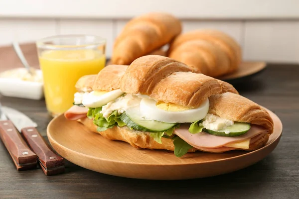 Leckeres Croissant-Sandwich mit Wurst auf dem Tisch — Stockfoto