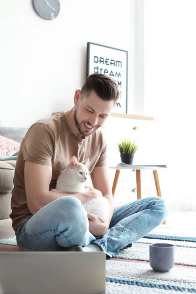 かわいい猫と自宅のラップトップを持つ若者 — ストック写真