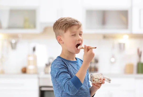 Liten pojke med yoghurt på suddig bakgrund — Stockfoto