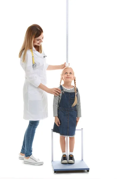 Beyaz arka plan üzerinde yükseklik ölçme küçük kızın doktor — Stok fotoğraf